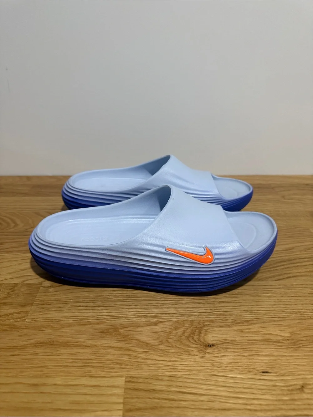 Brand new men’s size 9 Nike Rejuven8 Light Blue Slide Sandals with Orange Swoosh
